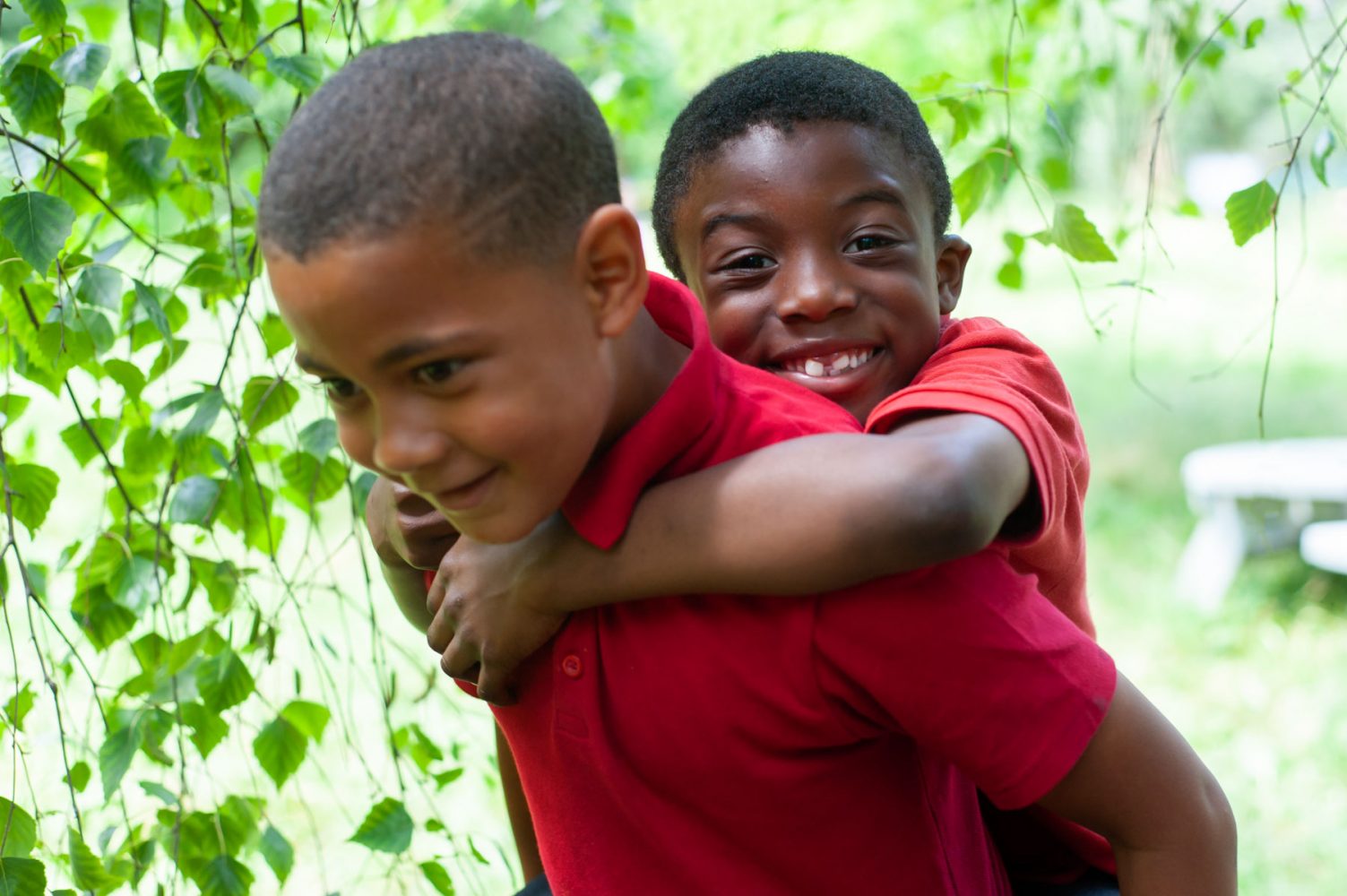 School pupils piggyback in garden